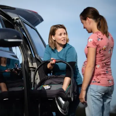 Children's Nebraska specialist helping new mother install car seat.