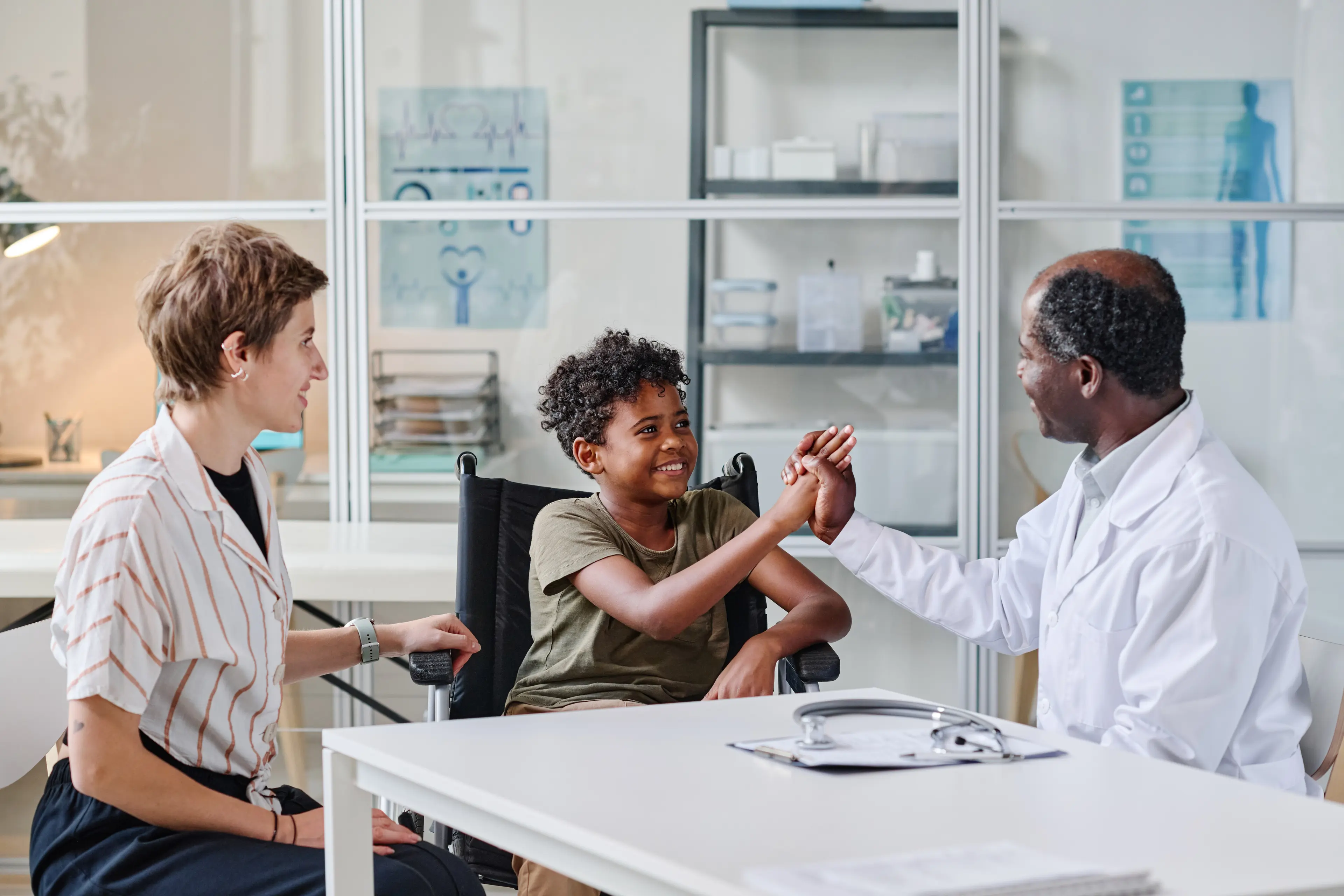 Doctor congratulating boy in office.
