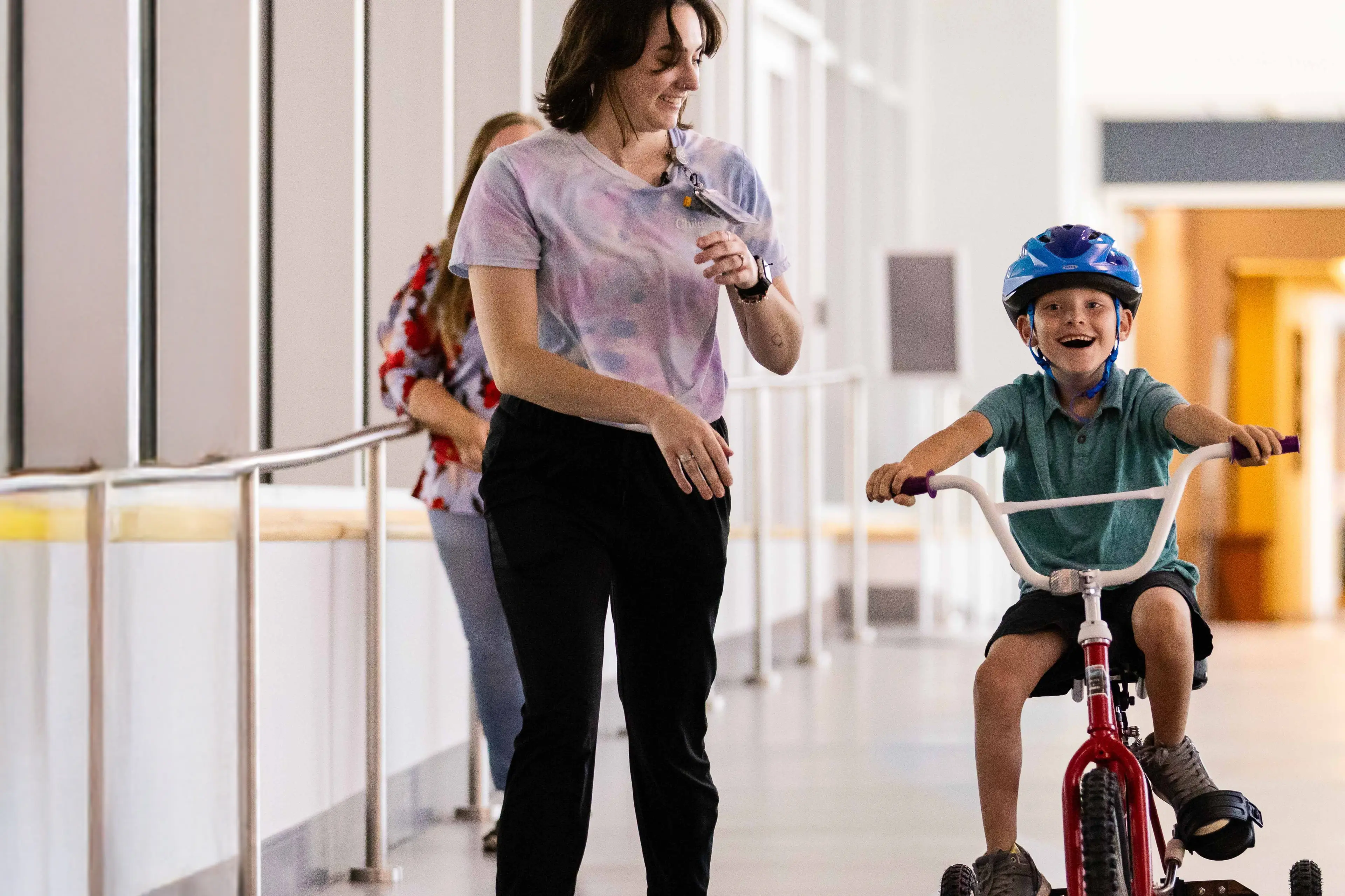 Young patient riding tricycle down Children's Nebraska hallway.