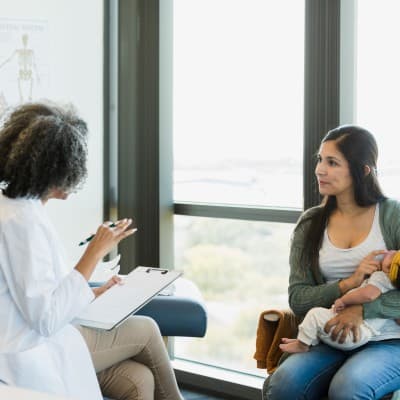 Mother talking to doctor about her child's care.