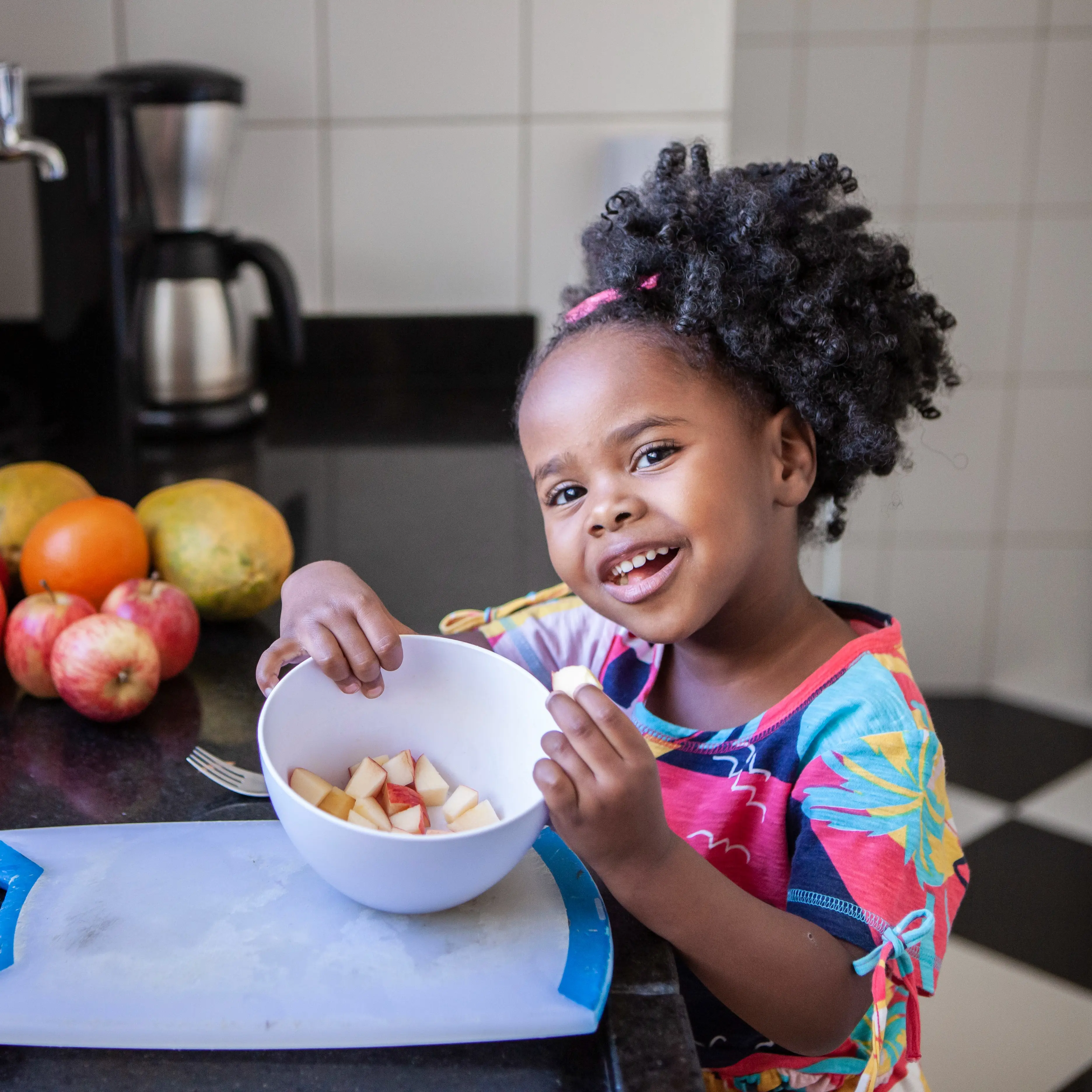 Young girl eating apple slices.