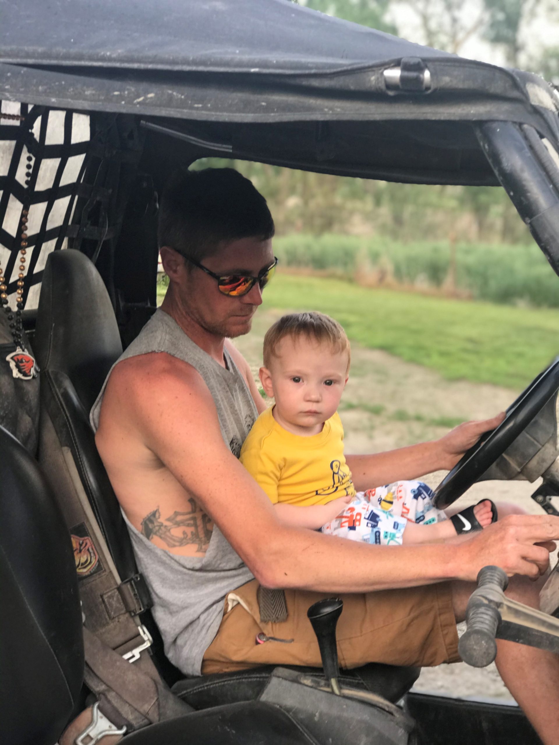 photo of jake and cash riding a tractor