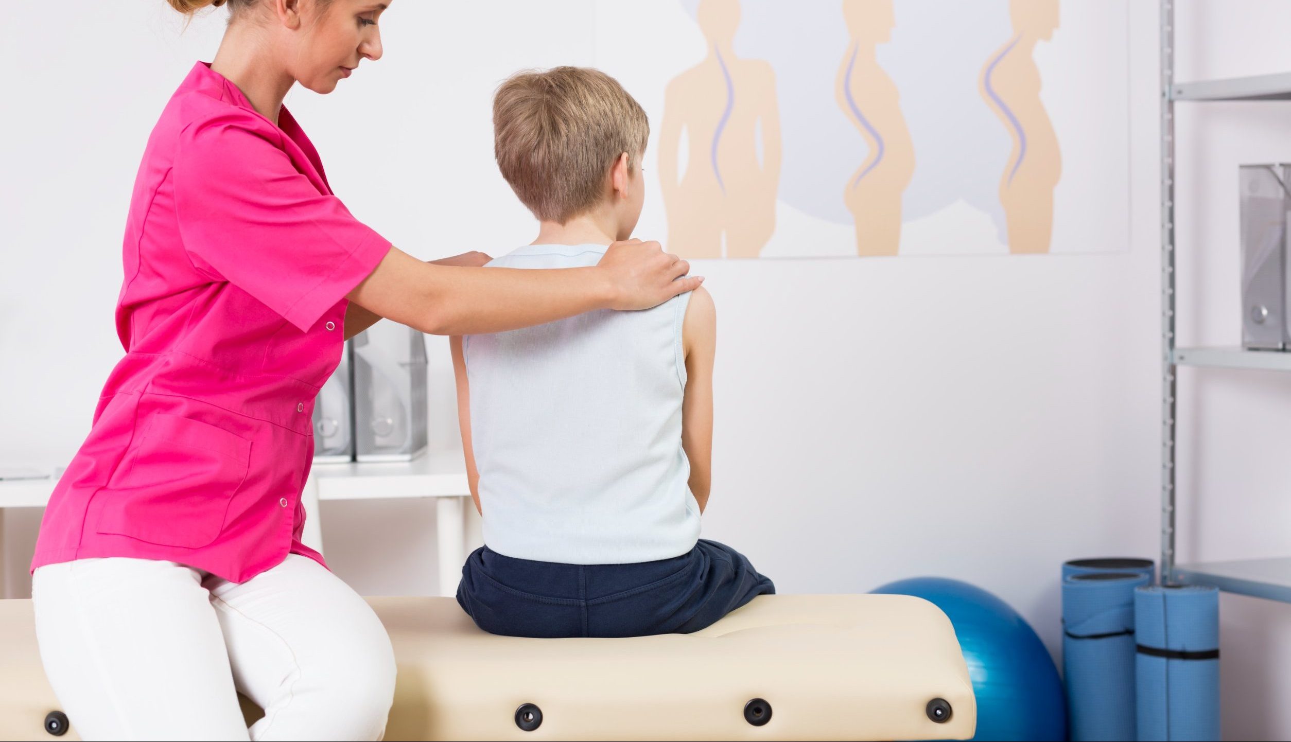 Provider correcting body posture of a small boy